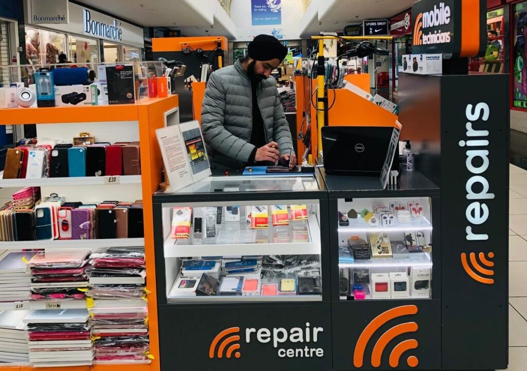 a man standing in front of a laptop computer in a store